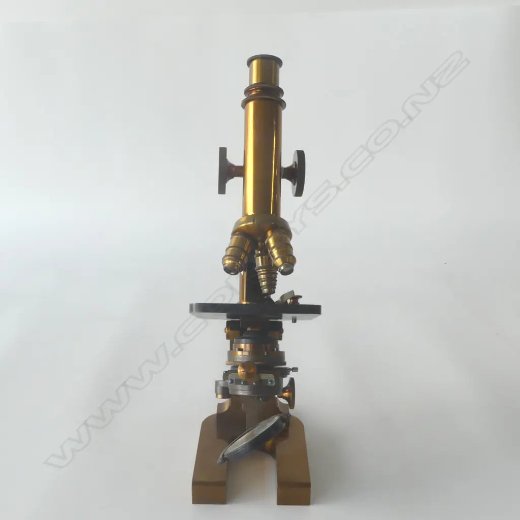 An Ed. Messter of Berlin lacquered brass compound microscope, rectangular horseshoe base, slotted pillar, tubular limb with triangular rod, topped by fine adjuster. Substage lens, iris diaphragm and double mirror. Body tube with double milled head pinion, triple objective lens swivel cluster. Signed and dated 1894 under the base. Provenance: ex The Jack Thornton estate collection. Image 1++