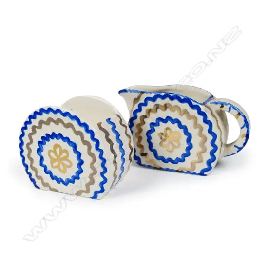 A rare c.1934 Eva Crofts for Clarice Cliff 'Art in Industry' Bizarre milk jug and sugar bowl, of Bonjour shape, gilt and blue concentric lines, black printed mark. H.60mm