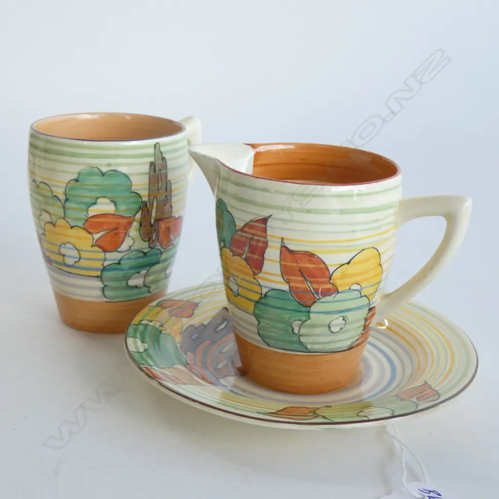 A Clarice Cliff Bizarre coffee cup and saucer and matching milk jug, floral pattern with concentric banding. Image 1++