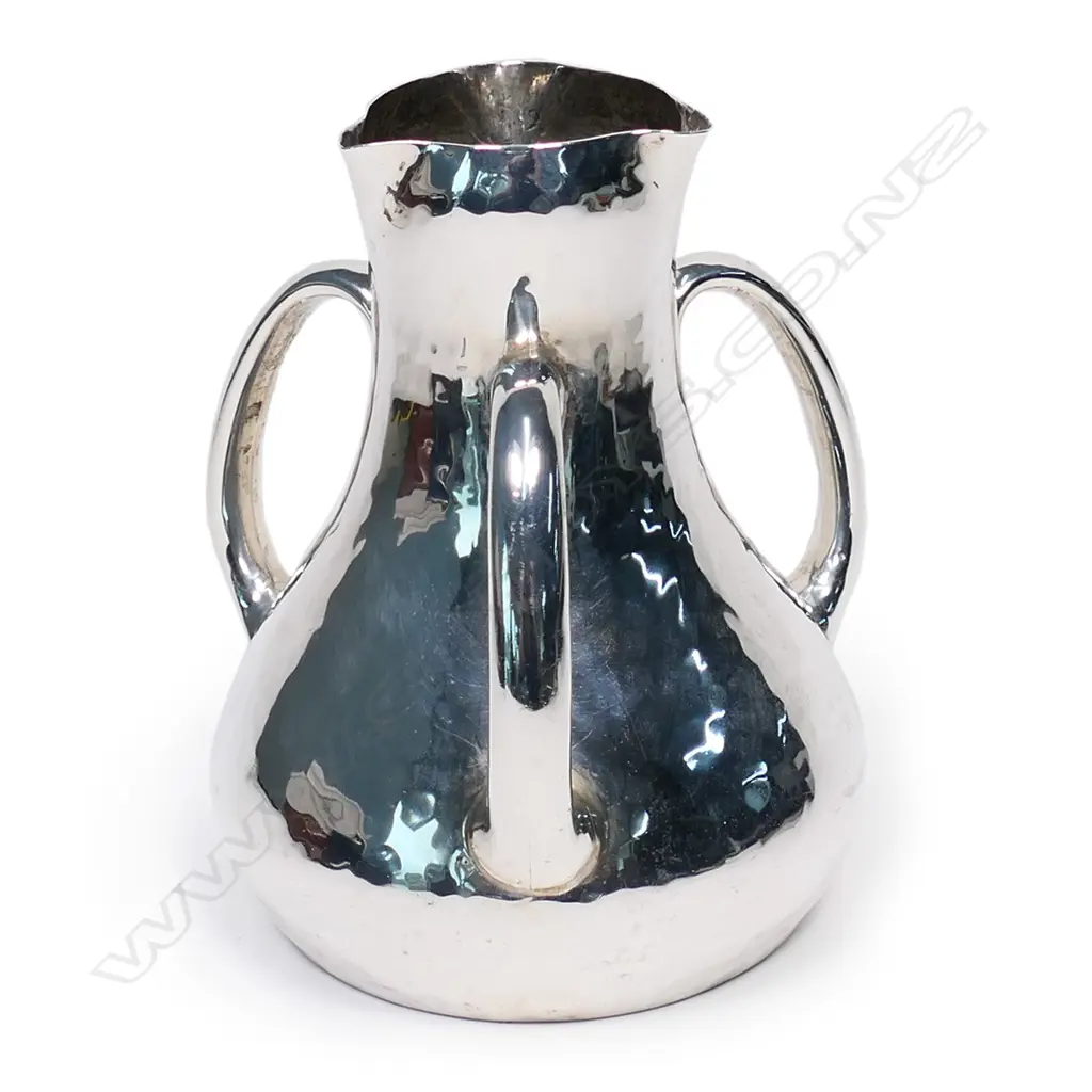 An Arts & Crafts silver tyg form vase. London 1903 by Charles Edwards for the Sussex Goldsmiths Co. Brighton, hammer finished baluster shape with three loop handles. H.145mm. 456gms. Image 1++