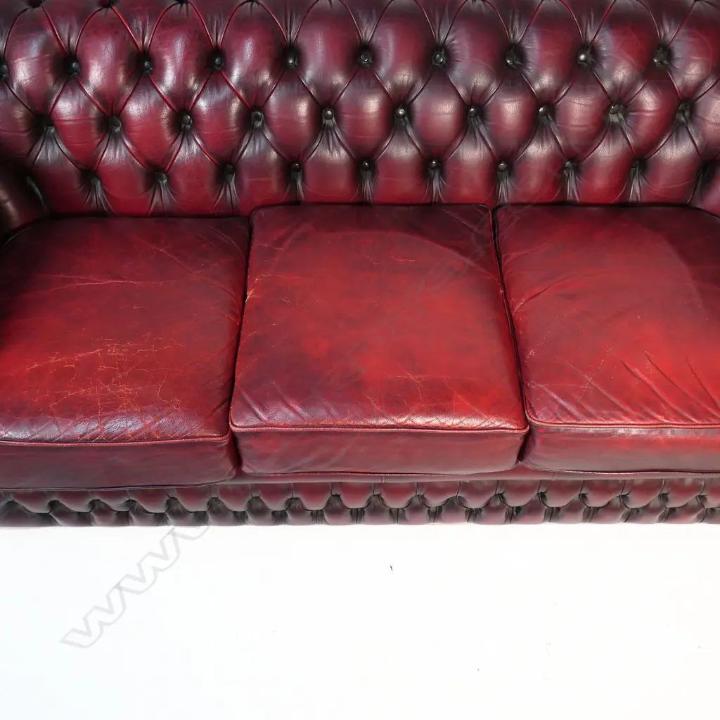 A Gascoigne 'Charles' Chesterfield three-seater sofa, upholstered in burgundy leather. 2140 x 900 x 750mm. Handmade by Gascoigne Leather Centre - an Australian furniture company. Image 1++