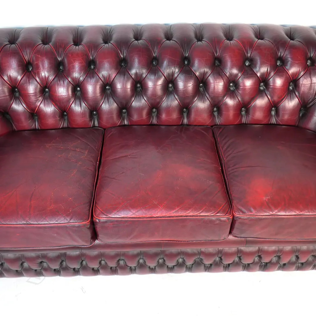 A Gascoigne 'Charles' Chesterfield three-seater sofa, upholstered in burgundy leather. 2140 x 900 x 750mm. Handmade by Gascoigne Leather Centre - an Australian furniture company. Image 1++