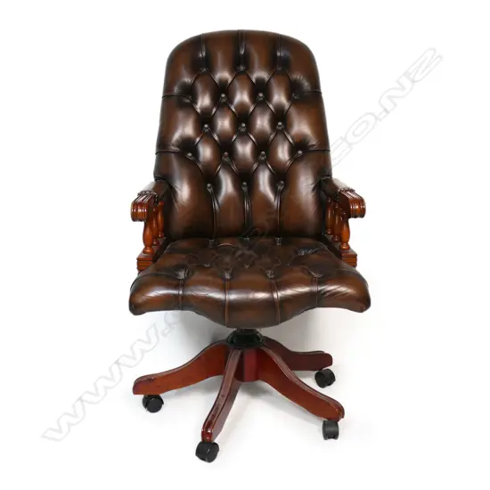 A Mountbatten-style leather buttoned-back swivel chair, in dark brown leather and mahogany. 650 x 480 x 1140mm