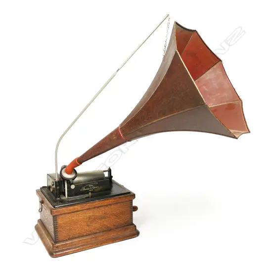 An early 20thC Edison wax roll 'Fireside Phonograph', in original oak case with domed hinged lid. Side wide handle operating, holding charge, apparently working, with maker's name plate with model details. The original red and gilt painted tin octagonal horn with Edison decal.