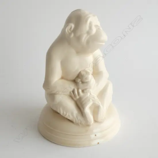 A Beswick monkey holding a piece of fruit