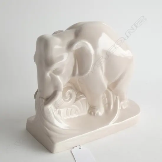 A Poole bookend shaped as elephant. Pale pink-mushroom monochrome glaze.