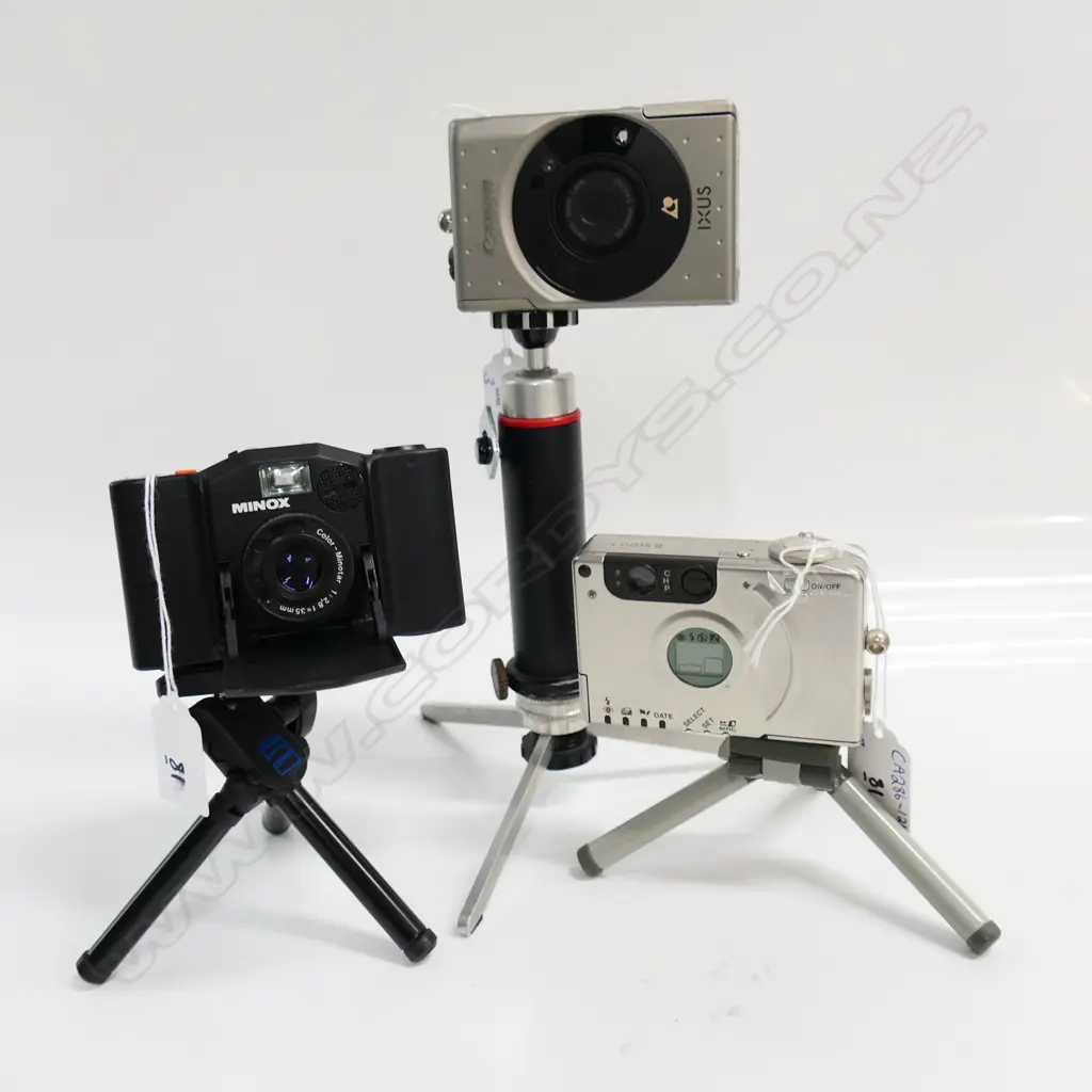 3 CAMERAS: CANON IXUS + MINOX 35GL,CANON IXUS II + CASE & MANUAL (on short tripods) Image 1++