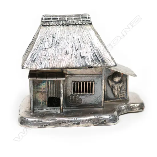 A vintage Eastern silver thatched bure cottage,