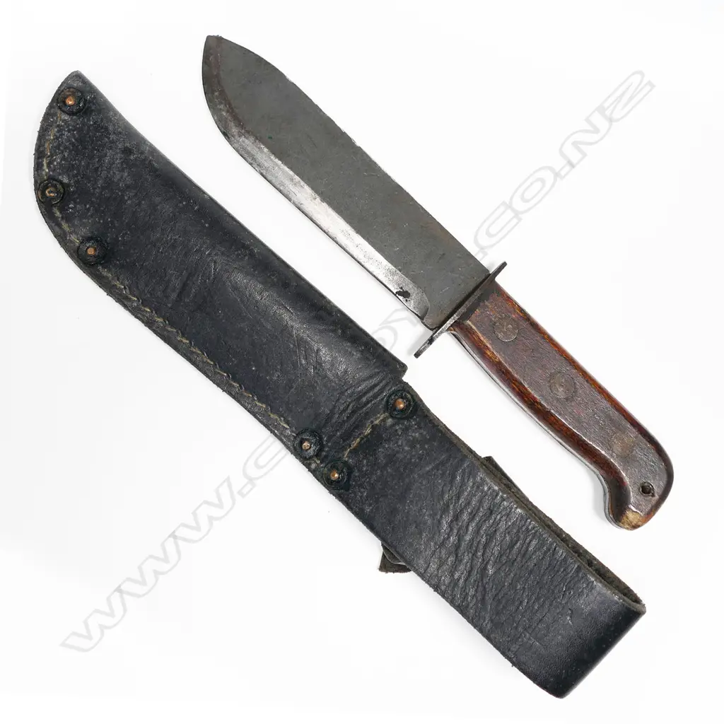Large heavy bowie type knife in leather scabbard. Appears to be the British type D Survival knife. Scabbard appears Australian issue. Blade numbered. L.310mm Image 1++