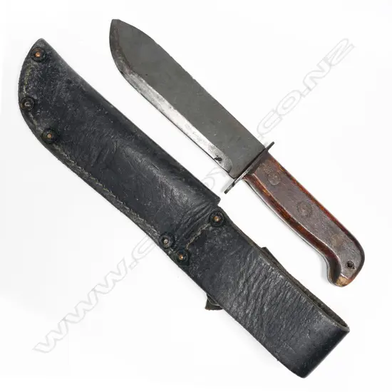 Large heavy bowie type knife in leather scabbard. Appears to be the British type D Survival knife. Scabbard appears Australian issue. Blade numbered. L.310mm