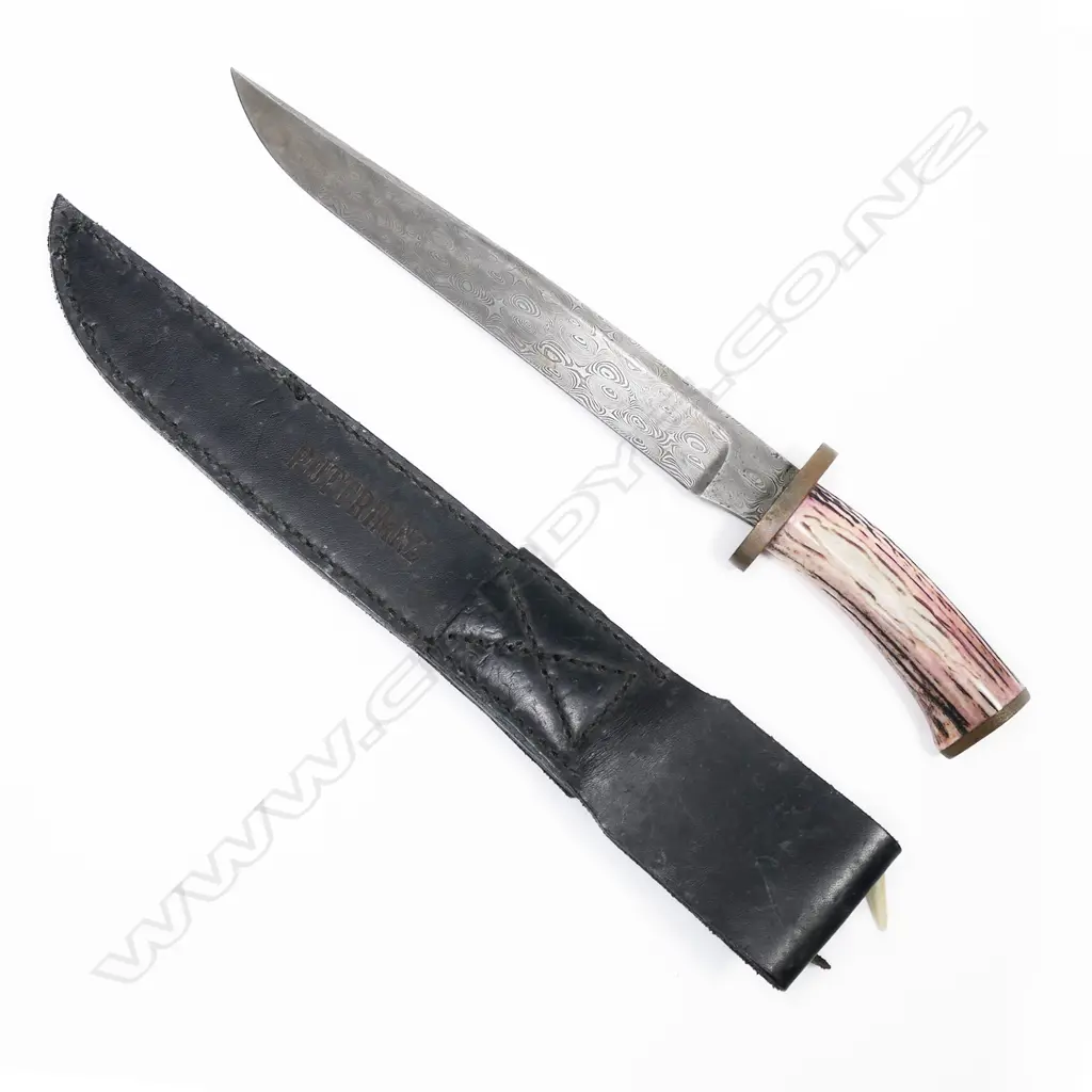 Large bowie / hunting knife with scabbard. Made from Damascus steel. Leather scabbard is marked Puttrim NZ.  L.400mm Image 1++