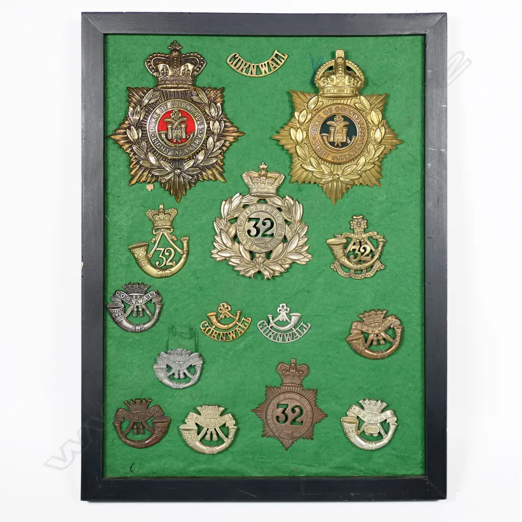 Framed Cornwall Regt badges (including Bakelite and Victorian helmet plate). 300 x 400mm Image 1++