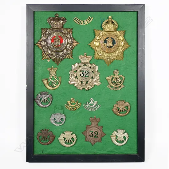 Framed Cornwall Regt badges (including Bakelite and Victorian helmet plate). 300 x 400mm