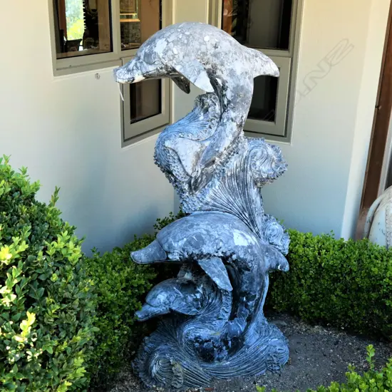 A tall carved marble dolphin sculpture