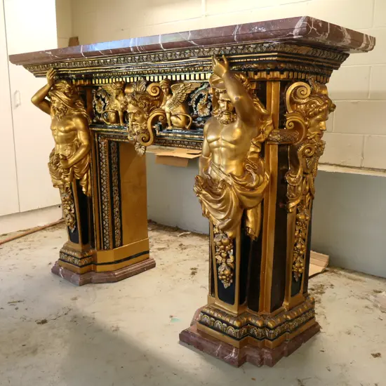 A Baroque style polychrome decorated cast bronze marble top fire surround