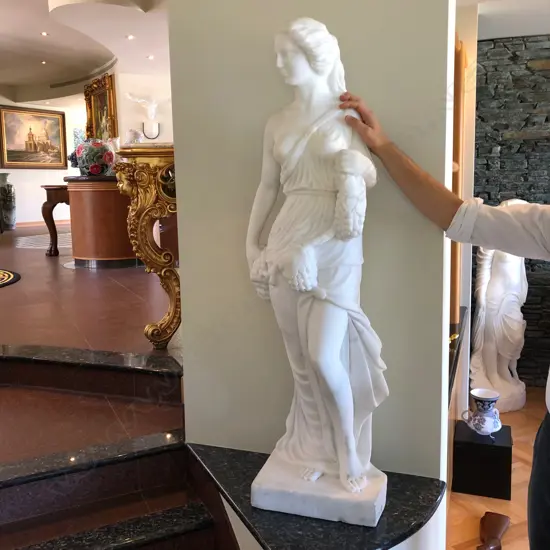 A tall classical carved white marble harvest goddess