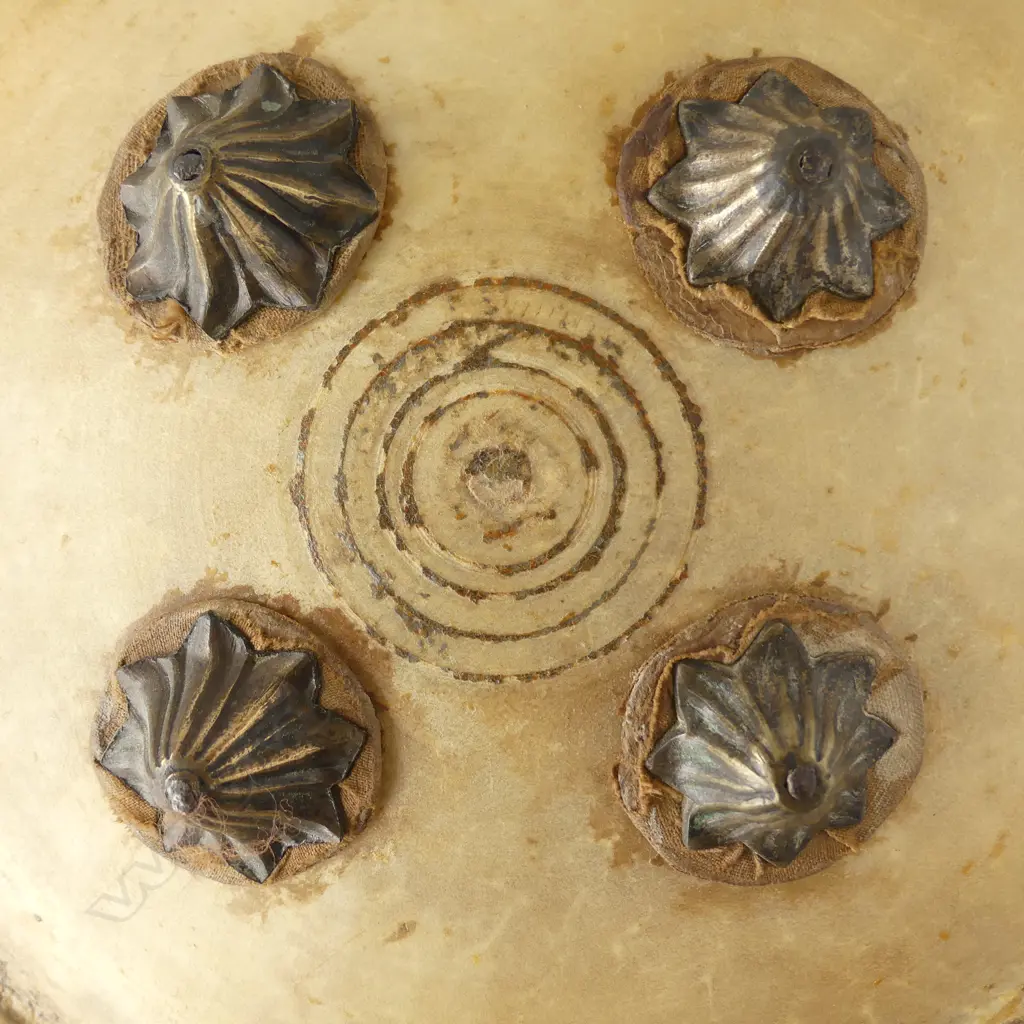 An uncommon Indian hide shield (dhal), probably rhinoceros, circular domed form, with remnant painted border decoration, four petal shaped bosses, Image 1++
