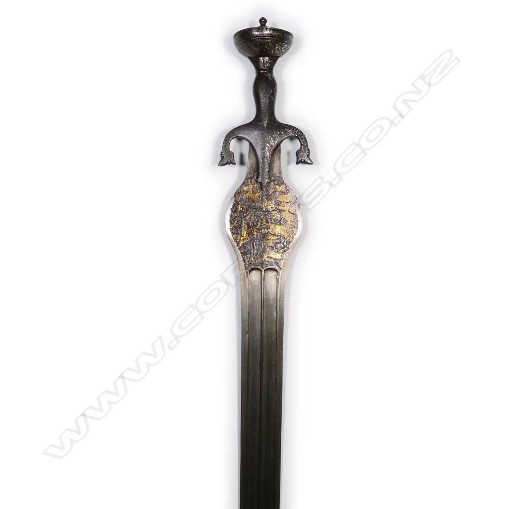 An Indian Pahari sword of unusual form, the broad flat blade with double edge and raised central ridge within a sunken panel. Image 1++