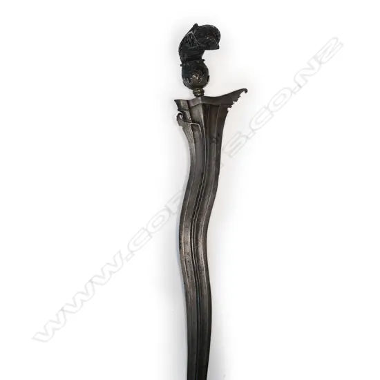A Javanese Kris with wavy edged tapering iron blade, hardwood hilt covered with flowers and scrolling foliage,