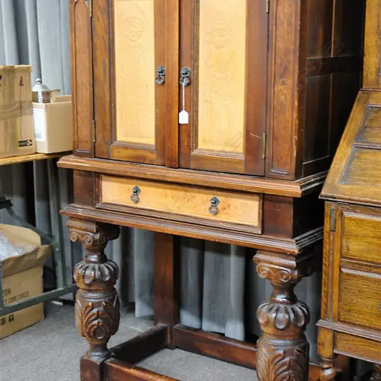 A small vintage Southland Beech two-door cabinet of English Tudor style