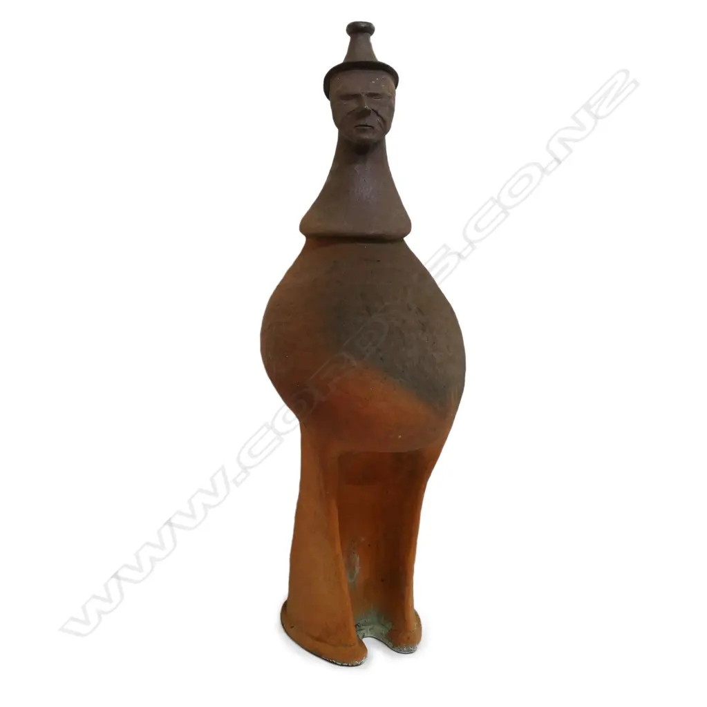 Barry Brickell (1935-2016) wood fired terracotta sculpture. A hand built anthropomorphic form morphing into a hatted bust, lower section of the stylised leg form with curved base. Unglazed with natural kiln firing variation. Chip and surface loss to foot edge. H.1250mm, Image 1++