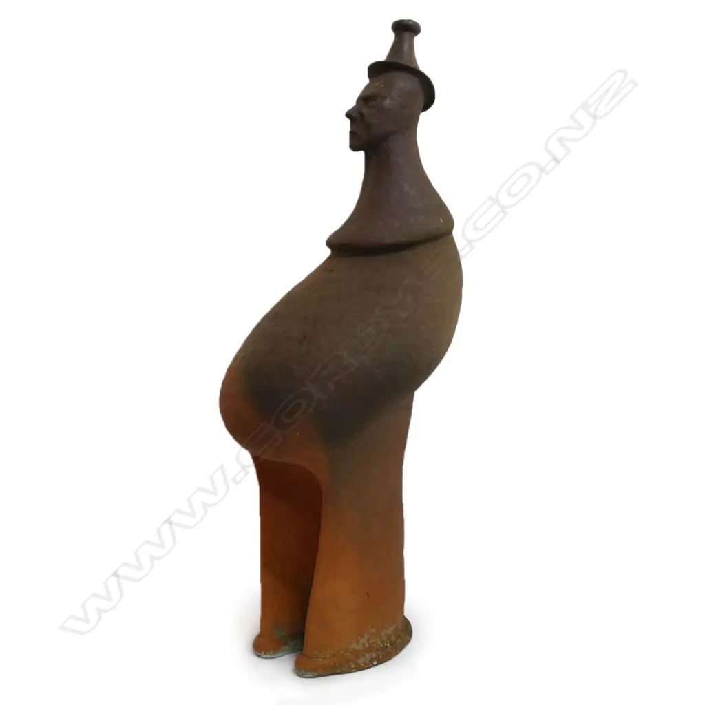 Barry Brickell (1935-2016) wood fired terracotta sculpture. A hand built anthropomorphic form morphing into a hatted bust, lower section of the stylised leg form with curved base. Unglazed with natural kiln firing variation. Chip and surface loss to foot edge. H.1250mm, Image 1++
