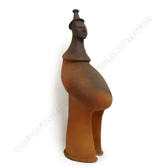 Barry Brickell (1935-2016) wood fired terracotta sculpture. A hand built anthropomorphic form morphing into a hatted bust, lower section of the stylised leg form with curved base. Unglazed with natural kiln firing variation. Chip and surface loss to foot edge. H.1250mm,
