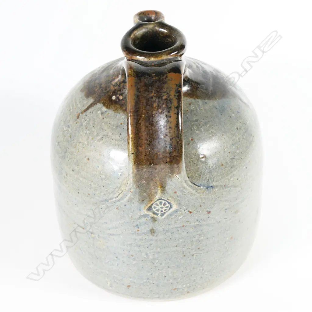 Barry Brickell (1935-2016) flagon; ash grey glazed bell form with tenmoko glazed strap handle and spout. Maker's mark to handle's base. H.200mm Dia.150mm Image 1++