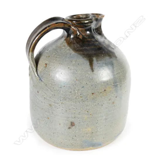 Barry Brickell (1935-2016) flagon; ash grey glazed bell form with tenmoko glazed strap handle and spout. Maker's mark to handle's base. H.200mm Dia.150mm