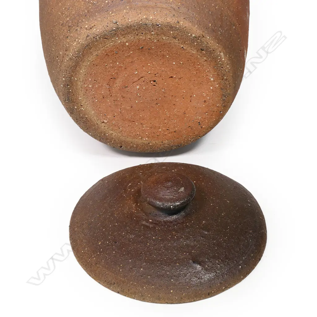 Barry Brickell (1935-2016) lidded storage jar with handles; variable brown and golden toned exterior with a collar of stamped motif. Glazed interior. H.500mm. Image 1++
