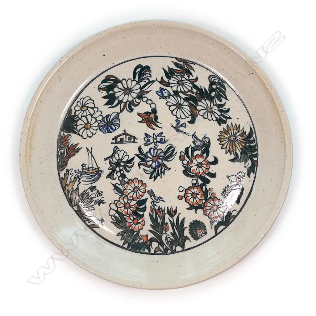 A large Roy Cowan pottery platter decorated with native flora and fauna designs together with iconic NZ subjects, various colours on a stone toned ground, etched initials to base. Dia.395mm. Image 1++