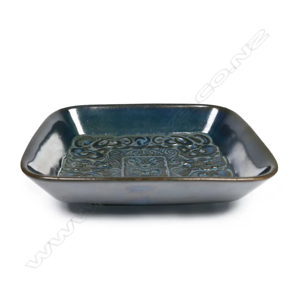 Crown Lynn Ngakura Ware dish - a rectangular dish in black-green glaze impressed with elaborate Māori designs. Unmarked on base. Designed by Crown Lynn for the tourist market and manufactured by Luke Adams in Christchurch. 120 x 150mm Image 1++