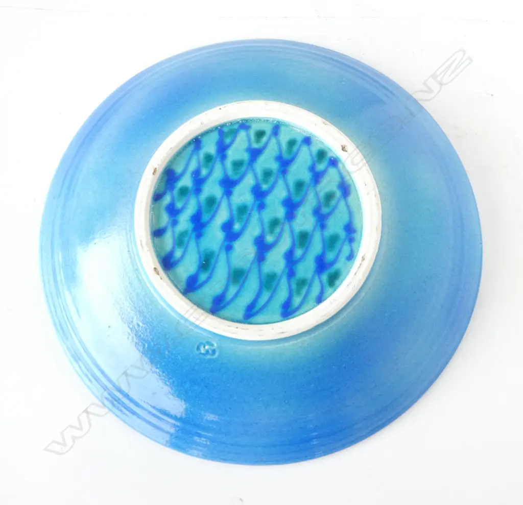 Merilyn Wiseman (1941-2019) round wide footed dish blue glazed with a central disc of repeating green and blue forms and flourishes to sides. Potter's mark lower side. Dia. 350mm Image 1++