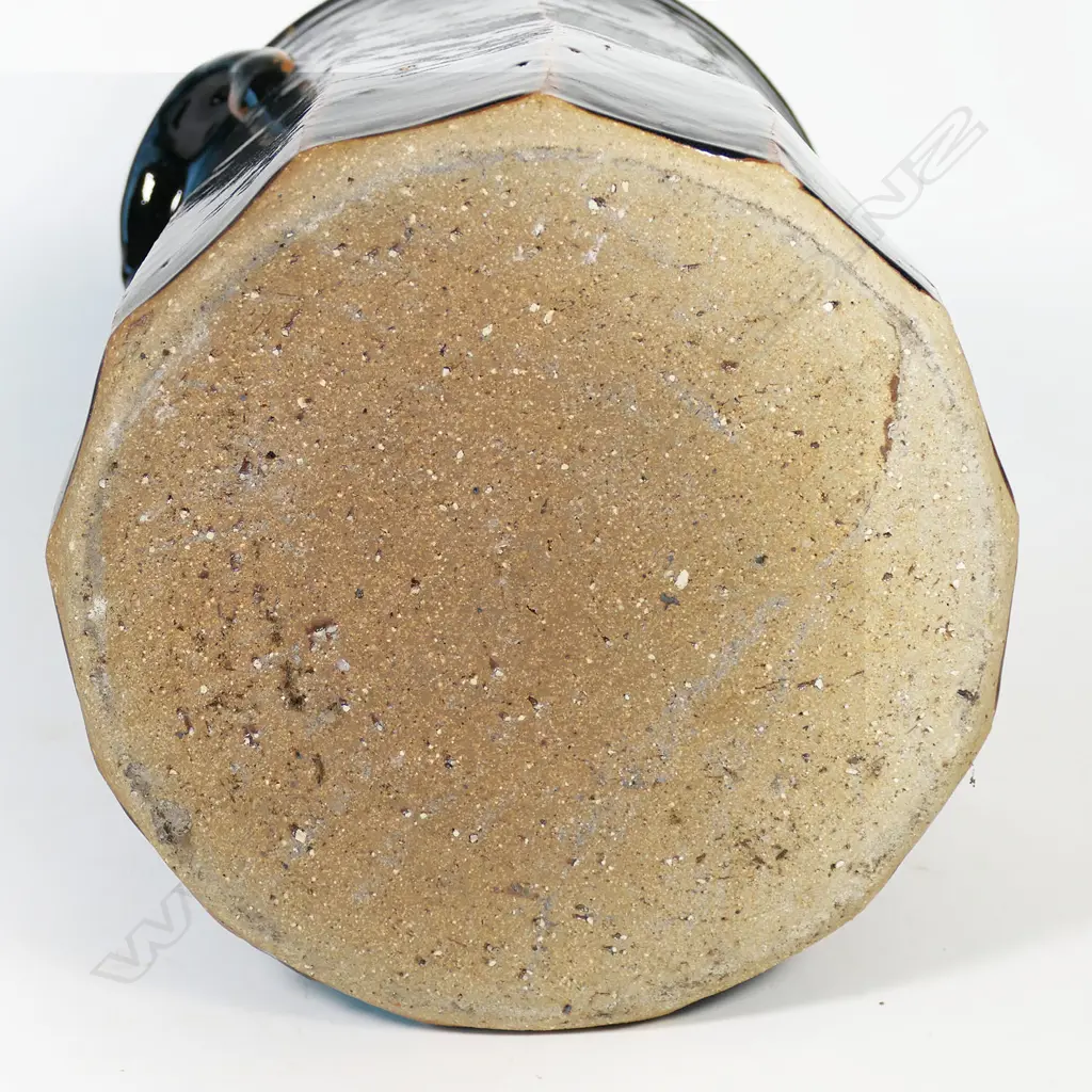 Peter Alger (Northland) tenmoku glazed large lidded storage vessel. Facet cut body with lug handles. The very well executed black tenmoku showing red/brown at the ridges. Impressed mark. H.365mm Image 1++