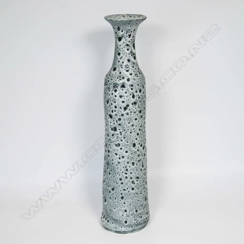 Graham Ambrose bubble glaze long bottle vase; the pale grey glaze on dark ground, long tapered cylindrical body. Impressed potters mark to base. H.540mm. Note: This unique high fired bubble glaze is one of four pieces made late 1990's early 2000's. Image 1++