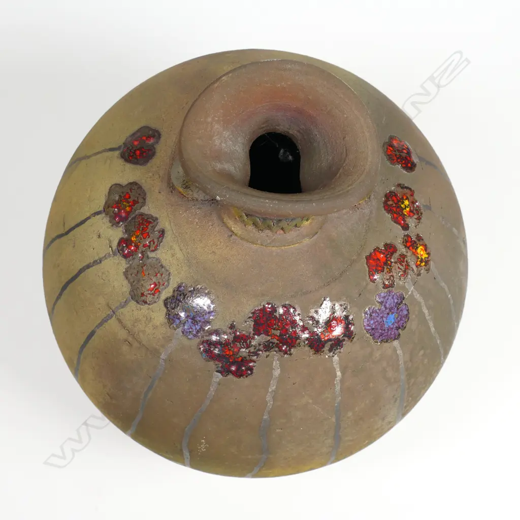 Mark James spherical vase; raku fired with altered mouth and lug handles. Decorated with overglazed flowers. Earth tones with copper glaze highlights. Potter's stamp to base. H.165mm Image 1++