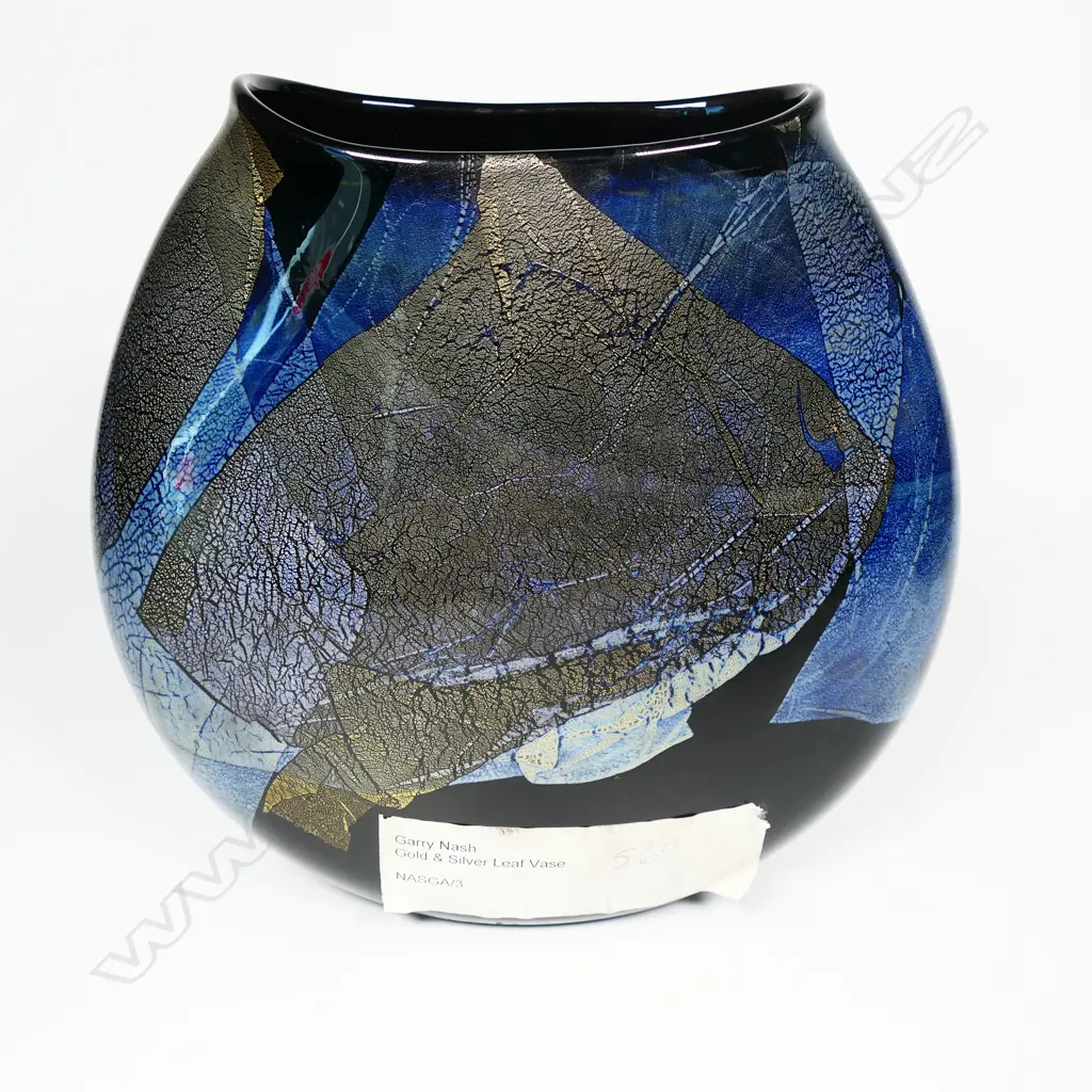 Garry Nash (ONZM) gold and silver leaf glass vase, of flattened ovoid form decorated with overlapping leaf patterns on a black ground. Signed and dated '03 to lower side. H.230mm Image 1++