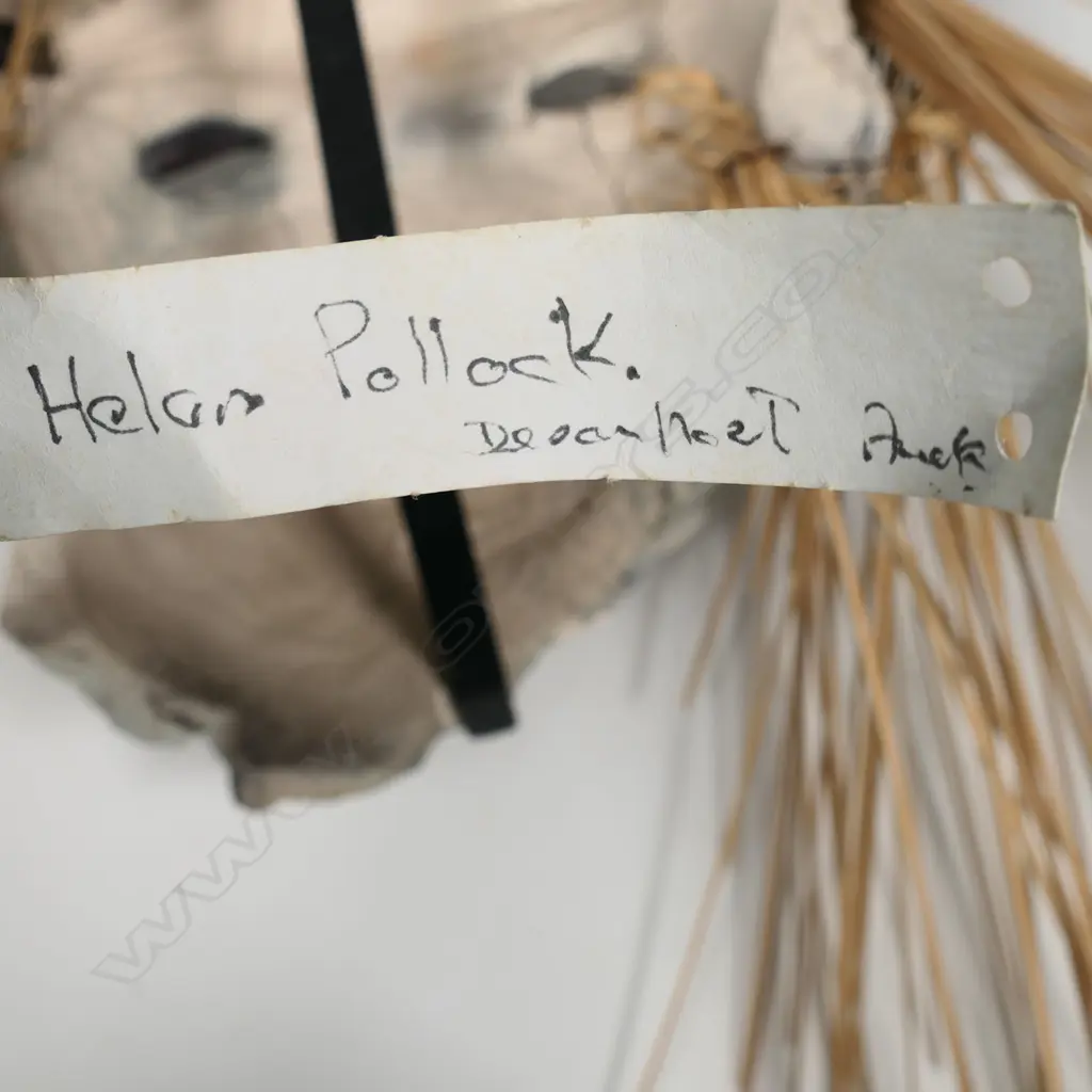 Helen Pollock raku fired mask with rope and reed adornment. Sturdy wall hanging assemblage to rear. Mask H.280 x 230mm, H.800mm total with reeds Image 1++