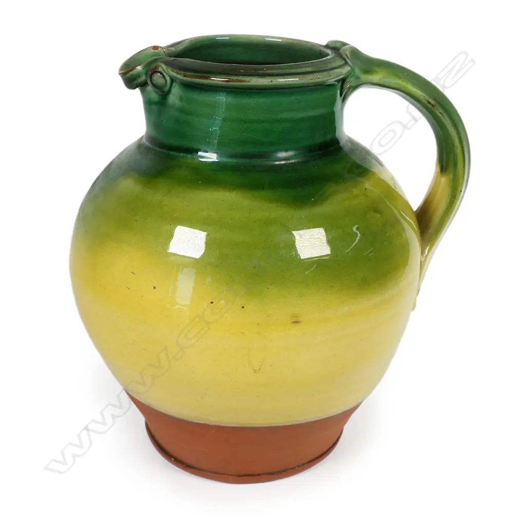 Andrew van der Putten large pitcher - with strap handle and a thick green glaze transitioning to yellow, potter's mark to base. H.200mm Image 1++