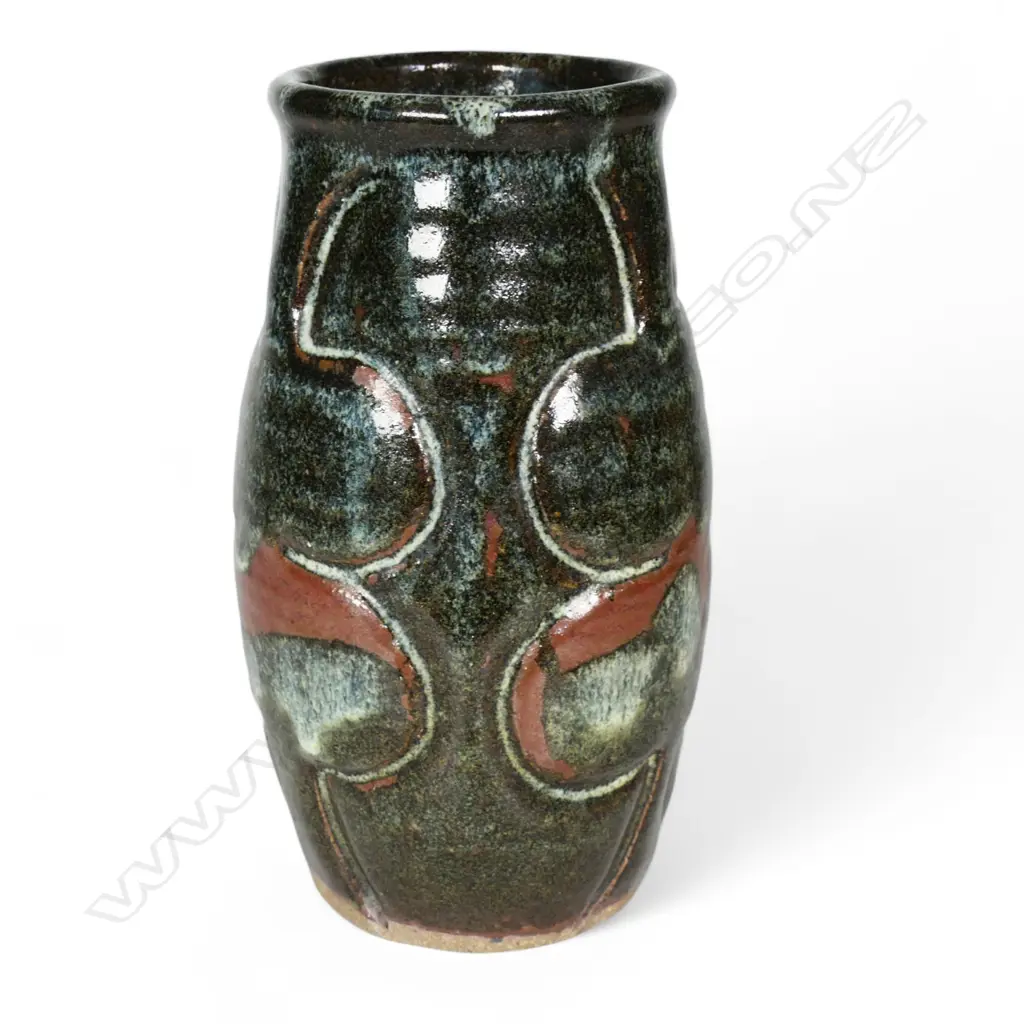 Jim Greig sculpted pottery vase, ovoid form with four relief sculpted double bladed (kotiate) forms, the dark brown/green glaze with pale and red/brown highlights, incised potter's mark to base. H.205mm. Image 1++