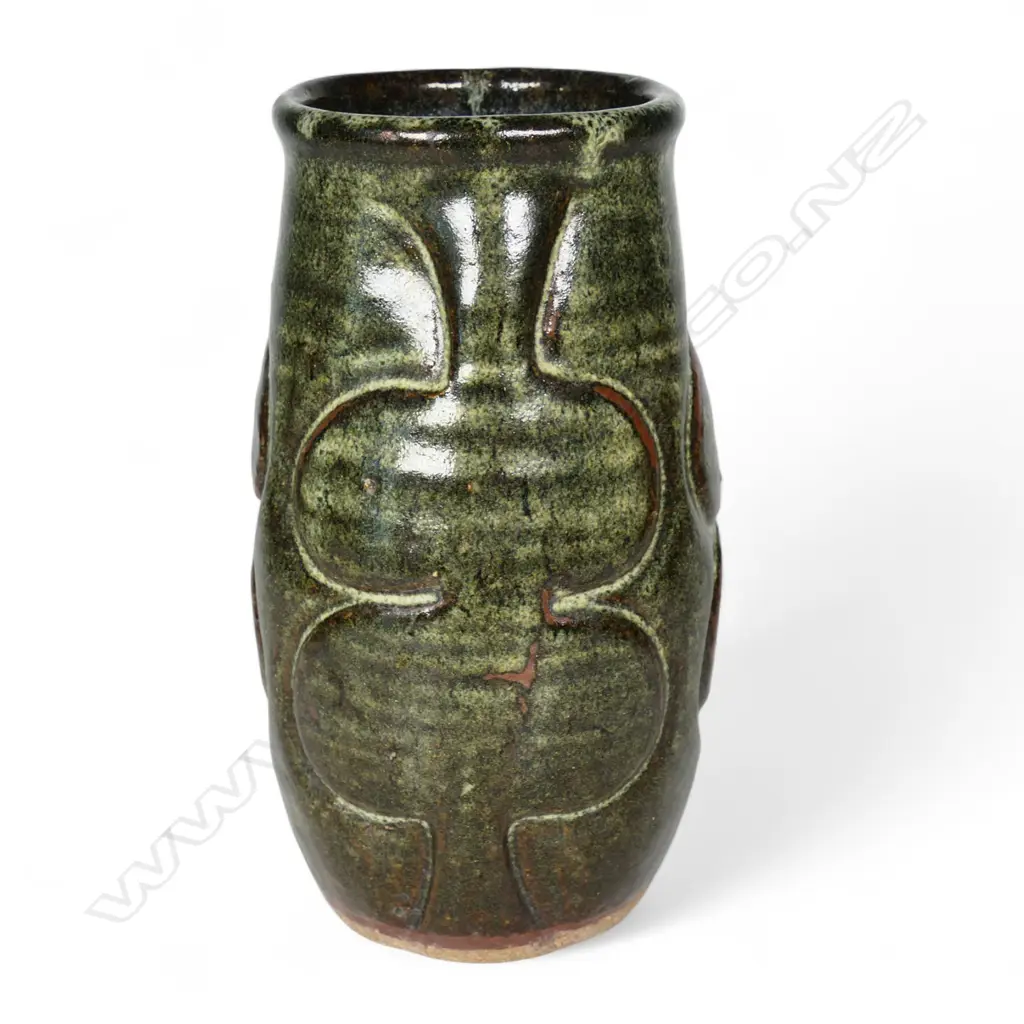 Jim Greig sculpted pottery vase, ovoid form with four relief sculpted double bladed (kotiate) forms, the dark brown/green glaze with pale and red/brown highlights, incised potter's mark to base. H.205mm. Image 1++