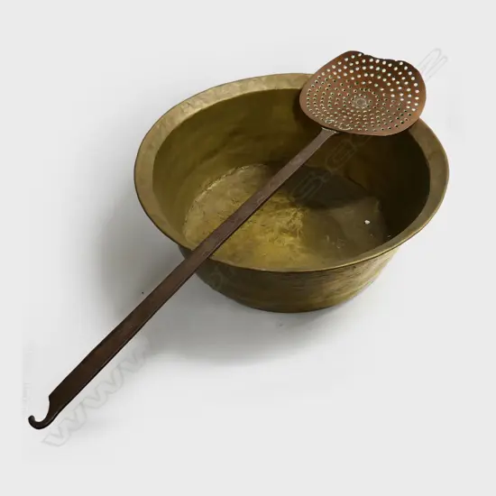 A large old pierced copper skimmer of dished oval shape on long hooked iron handle. L.1300mm along with a very large brass cauldron. Dia.630mm