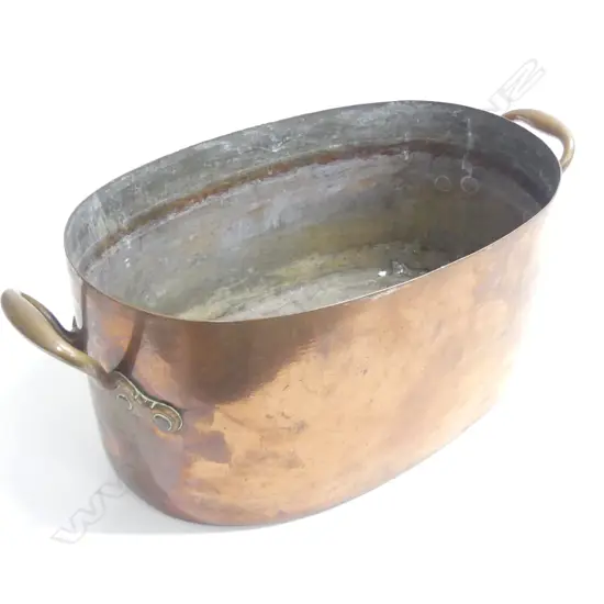 A large oval copper two handled pan. W.540mm across handles.