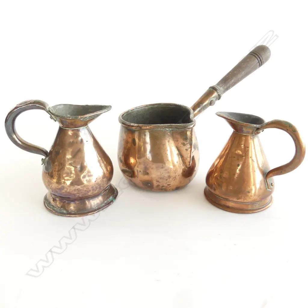 A 19thC copper saucepan, with side handle with socket fitted wooden grip; along with two copper measures. Image 1++