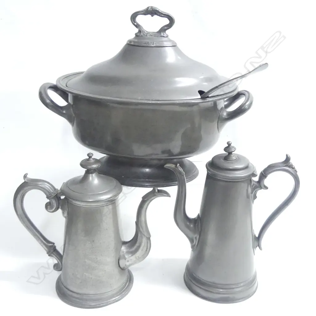 A Victorian pewter two-handled oval soup tureen, L.370mm, together with a fiddle pattern ladle; along with two early pewter coffee pots with tapered cylindrical bodies, scroll handles, the domed lids with knob finials. H.255 and 240mm. Image 1++