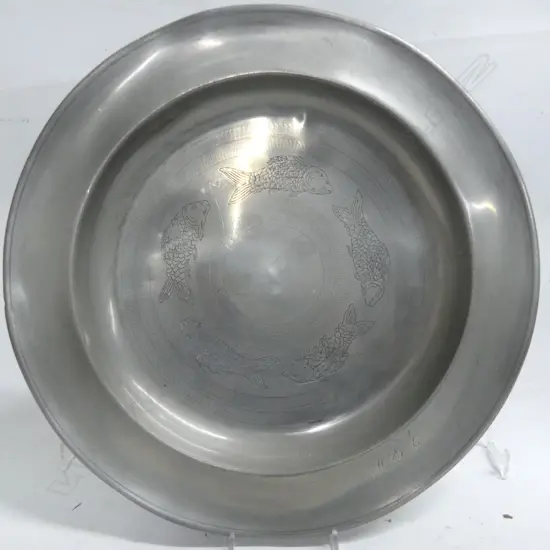 A 19thC pewter dish engraved with circling fish and dated 1839,