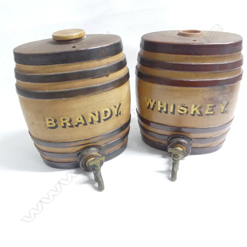 Two Victorian period stoneware spirit barrels: marked ‘Brandy’ and ‘Whisky’ in gilt lettering, brown glazed with three darker bands, both with brass taps, one retaining original stoneware top.  H.270mm Image 1++