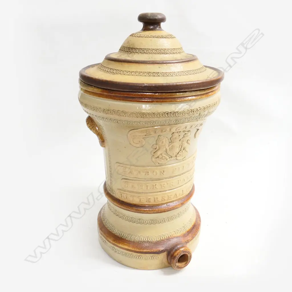 A Victorian Dahlkes stoneware water filter-, the front with ribbons ‘Dahlkes Patent Silicated Carbon Filter Co.’ and Royal crest, lidded. H.420mm. Image 1++