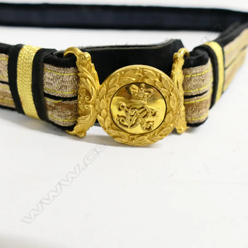 A Victorian officer's black cloth 1¾" wide dress belt with bullion braid and an ornate gilt belt buckle with ‘Crown’ and ‘VR’ surrounded by leaves Image 1++
