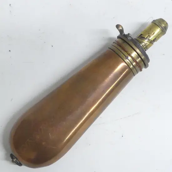 A  copper and brass gunpowder flask with graduated dispenser nozzle